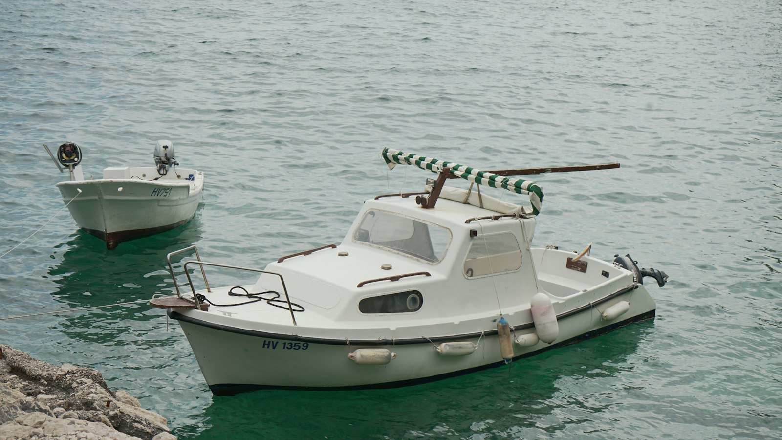 Piccole barche a motore ormeggiate in acqua limpida