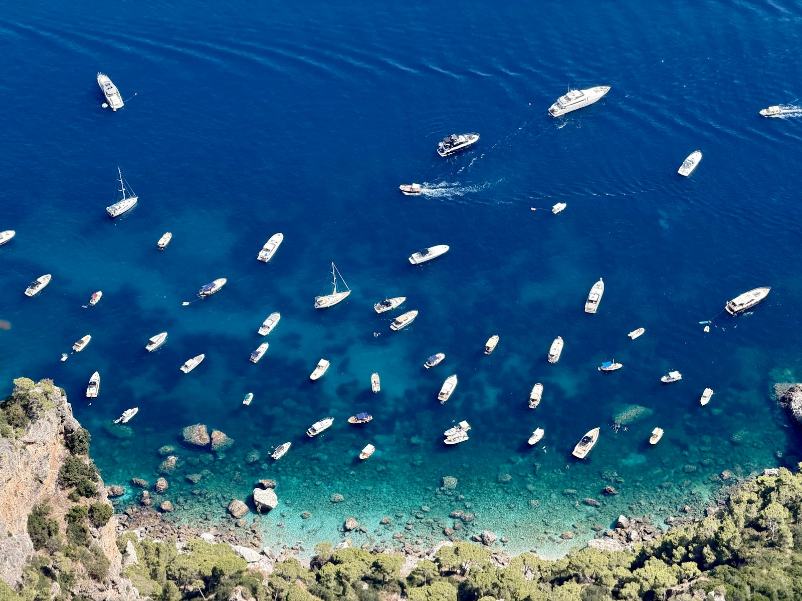Barche in una baia di acqua turchese lungo la costa